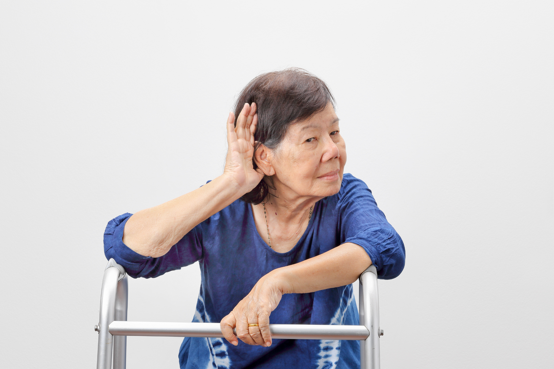 Old lady cupping her ear due to hearing loss