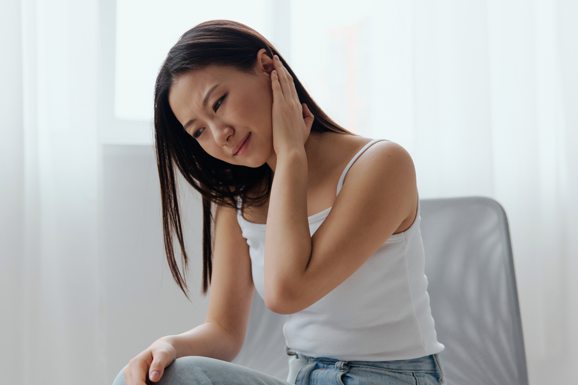 Wanita menyentuh telinganya kerana sakit telinga